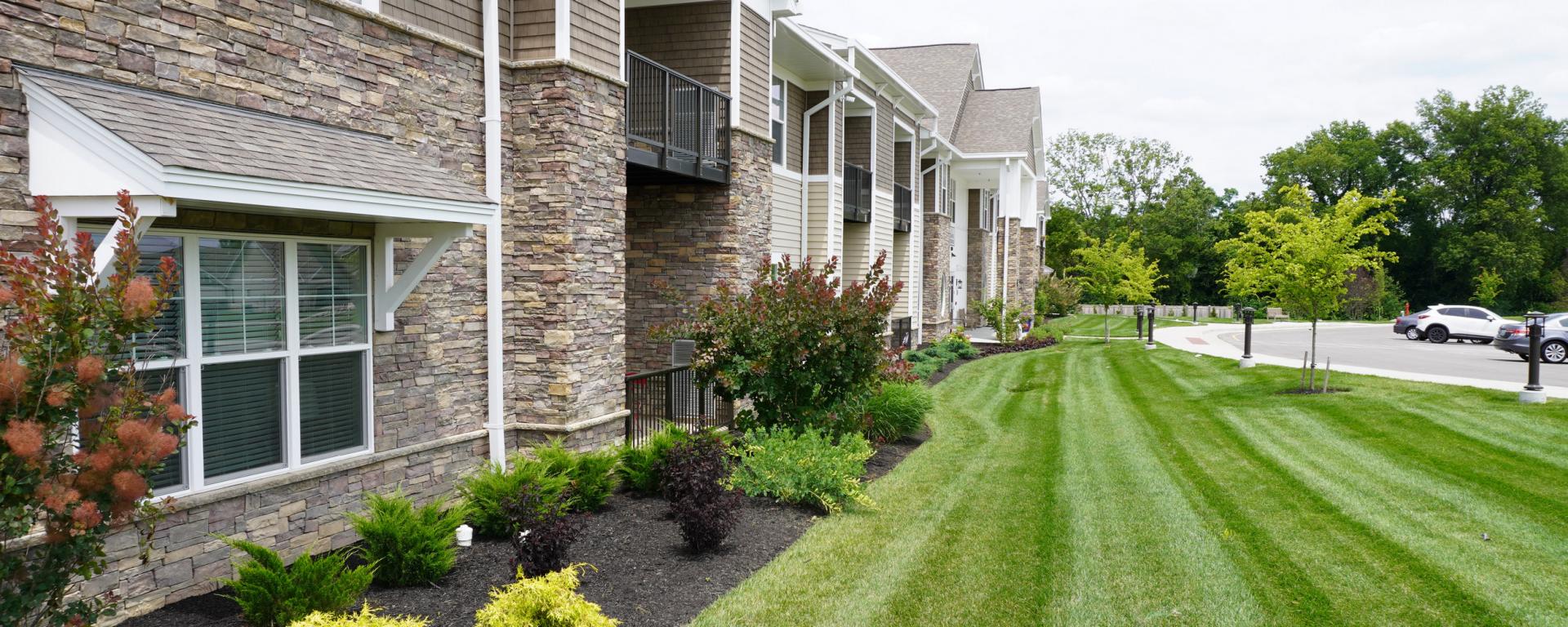 green plants and lawn outside senior living apartment building