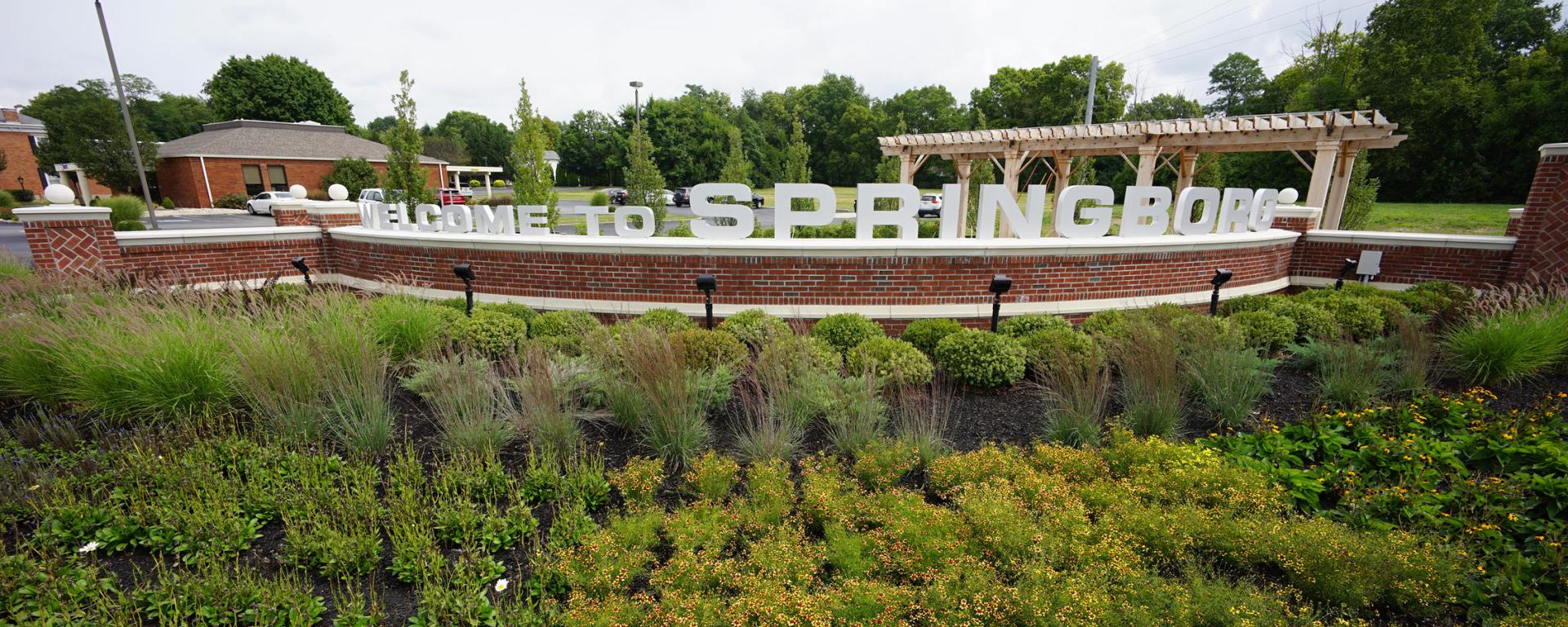 welcome sign with green plants surrounding