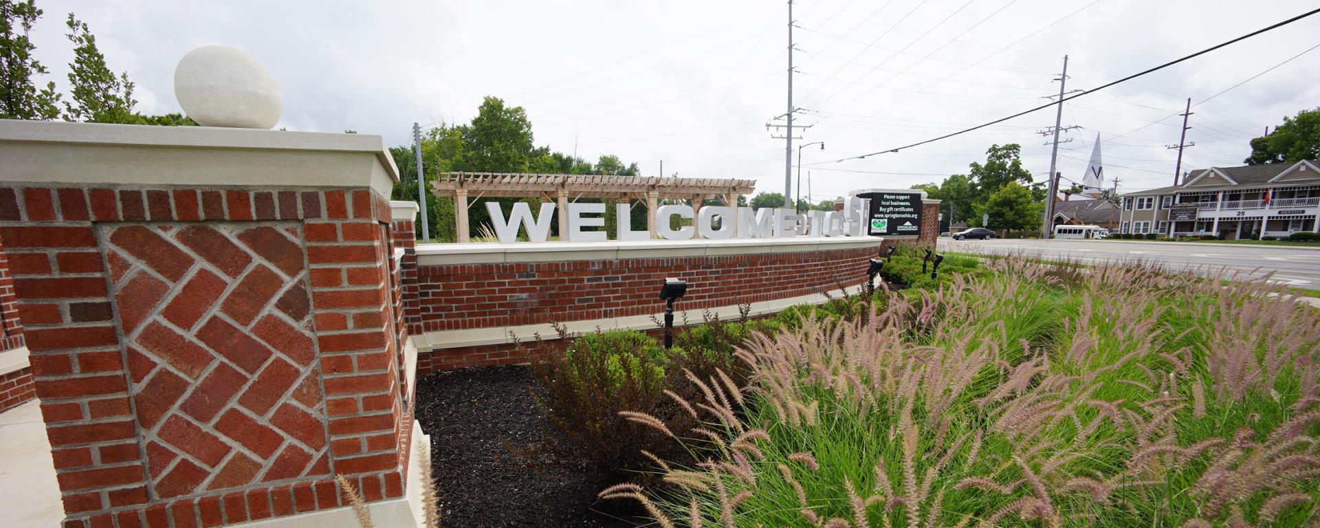 brick entry sign with green plants