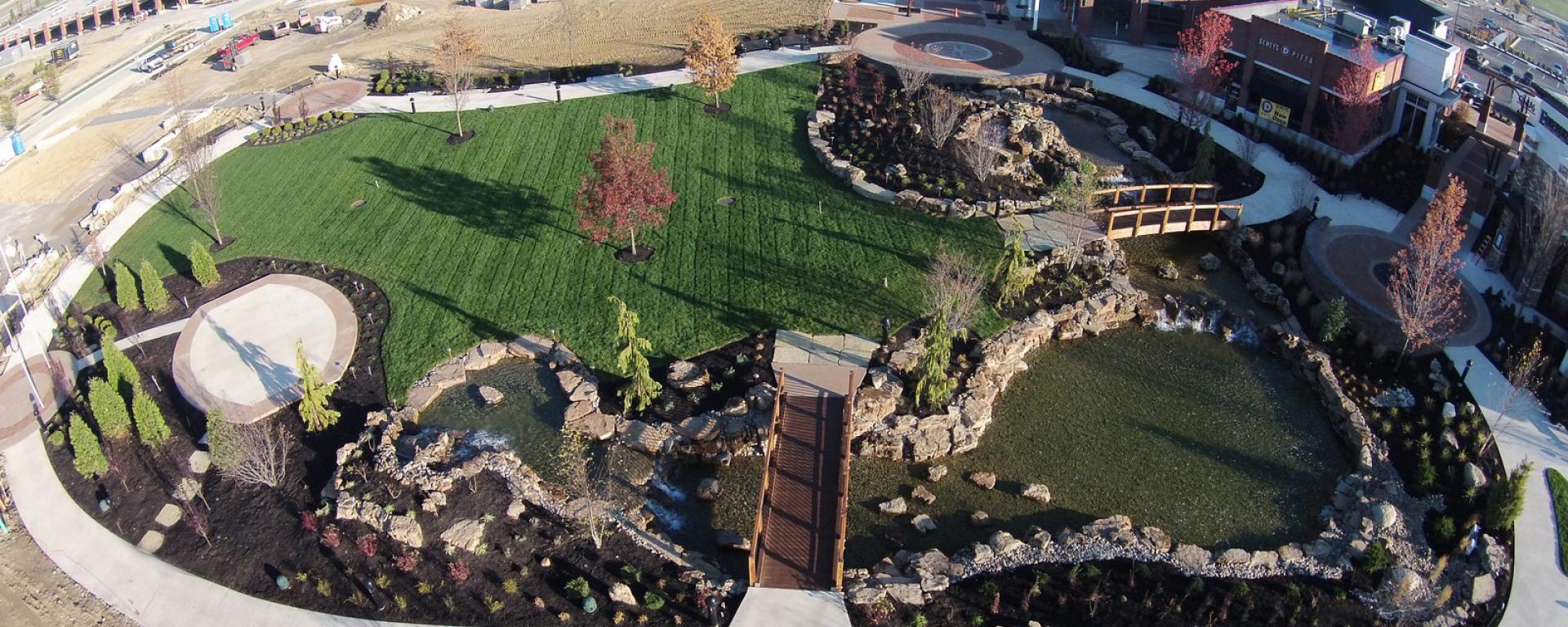 aerial image of park featuring pond 