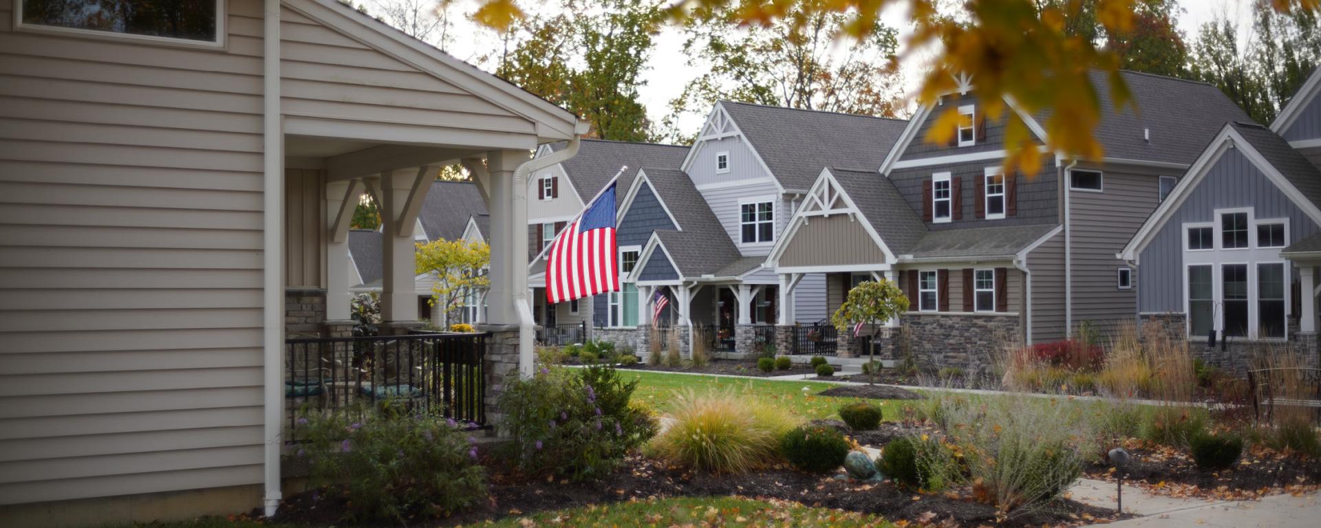 houses in a row during the fall with american flag