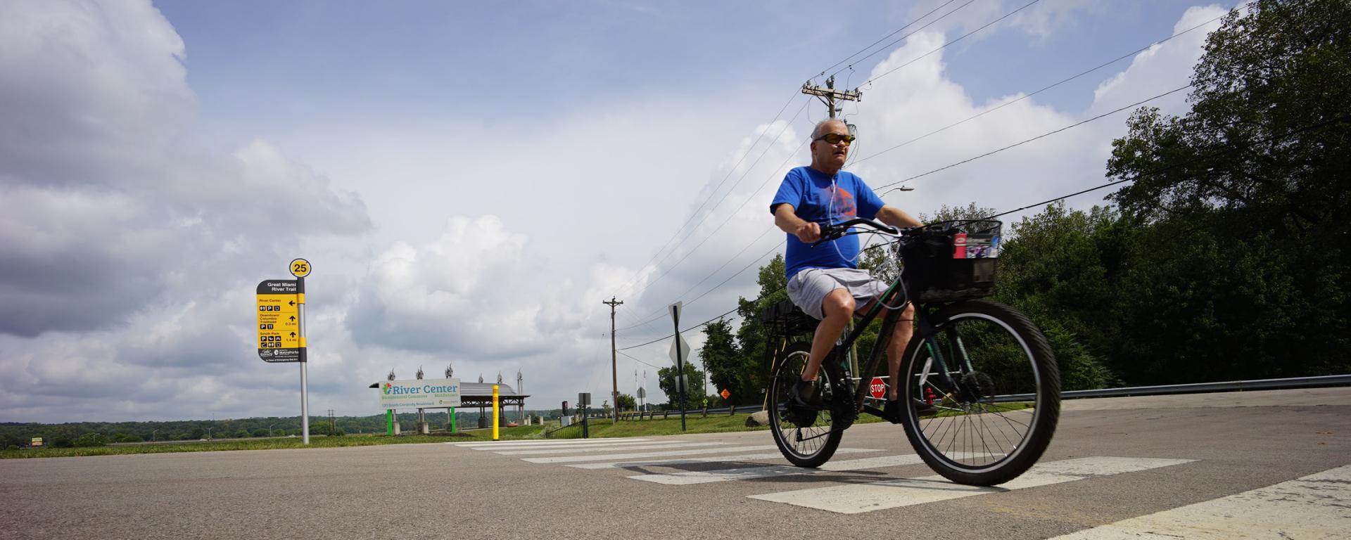 man riding bike across a street