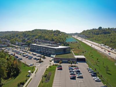 aerial of facility and parking lot, featuring highway in the back