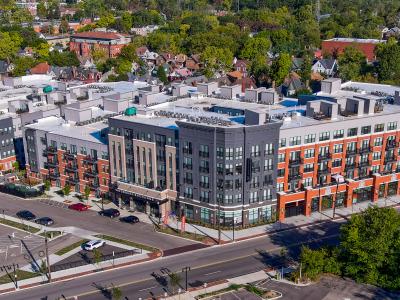 aerial photo of apartment building with parking garage in urban neighborhood