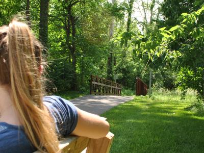 girl on bench by park trail