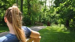 girl on bench by park trail